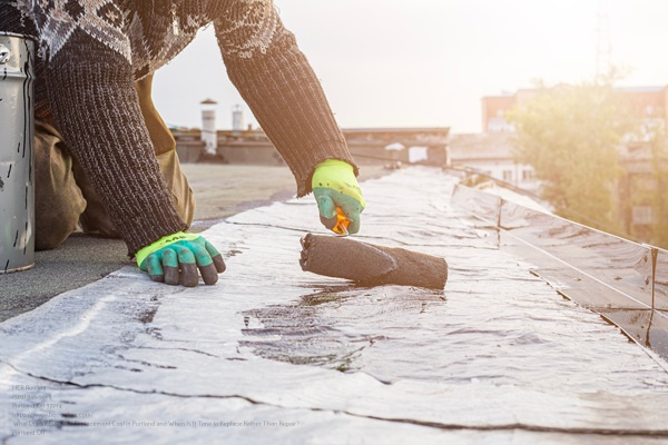 A Young Worker Treats A Roof With Bitumen Primer Before Applying